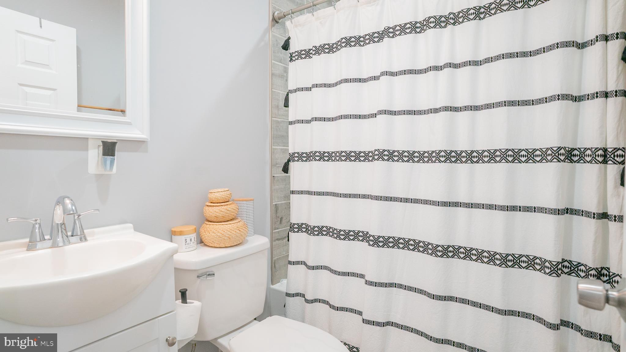 2438 West Seybert Street Philadelphia, PA 19121 - Photo 18 of 21 a bathroom with a white bath tub and a shower curtain