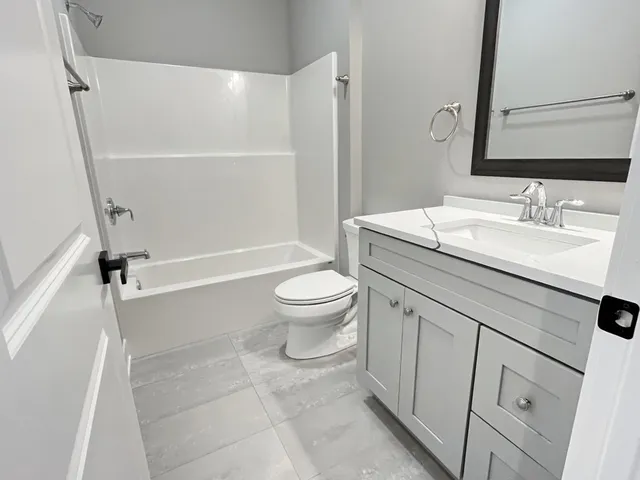 a bathroom with a sink a toilet and a mirror