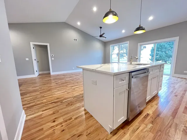 a kitchen with kitchen island granite countertop a sink and a stove