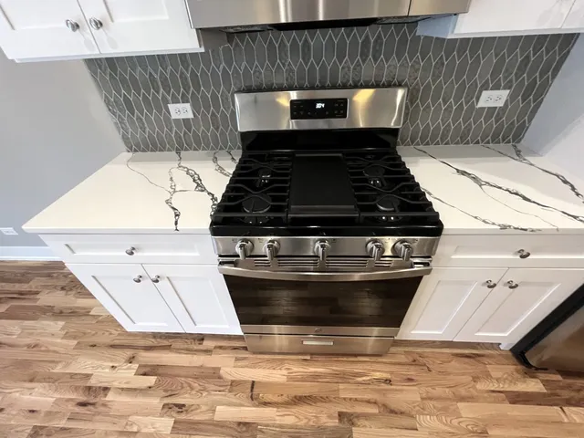 a stove top oven sitting inside of a kitchen