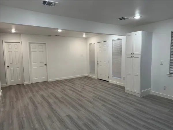 an empty room with wooden floor and white walls