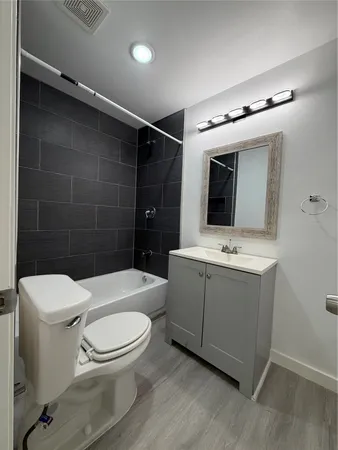 a bathroom with a toilet a sink and mirror