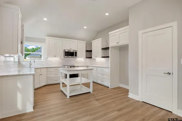 a kitchen with white cabinets and stainless steel appliances
