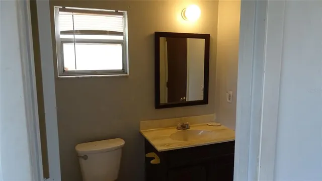 a bathroom with a toilet sink and mirror