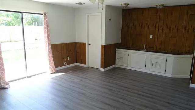 an empty room with wooden floor and cabinet
