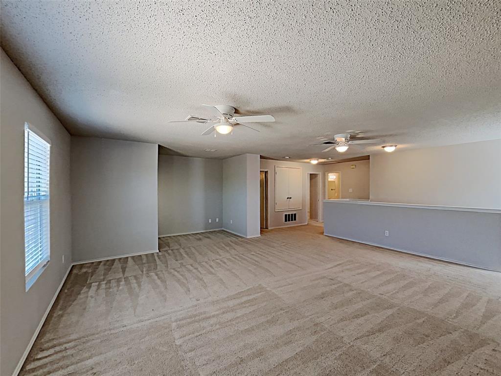 2104 Navada Way Fort Worth, TX 76247 - Photo 14 of 19 en empty room with windows and ceiling fan