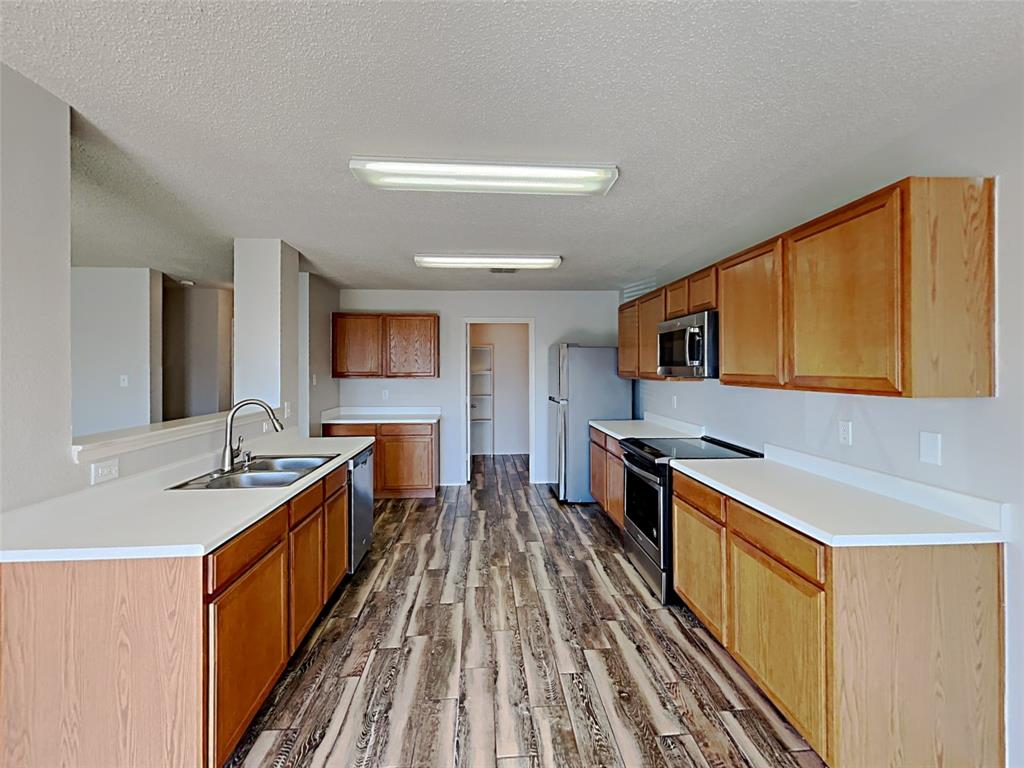 2104 Navada Way Fort Worth, TX 76247 - Photo 3 of 19 a kitchen with stainless steel appliances granite countertop a stove and a sink