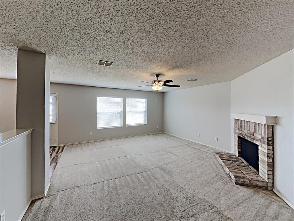 2104 Navada Way Fort Worth, TX 76247 - Photo 5 of 19 a view of an empty room with a fireplace and a window