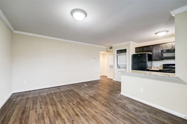 an empty room with wooden floor and a fireplace
