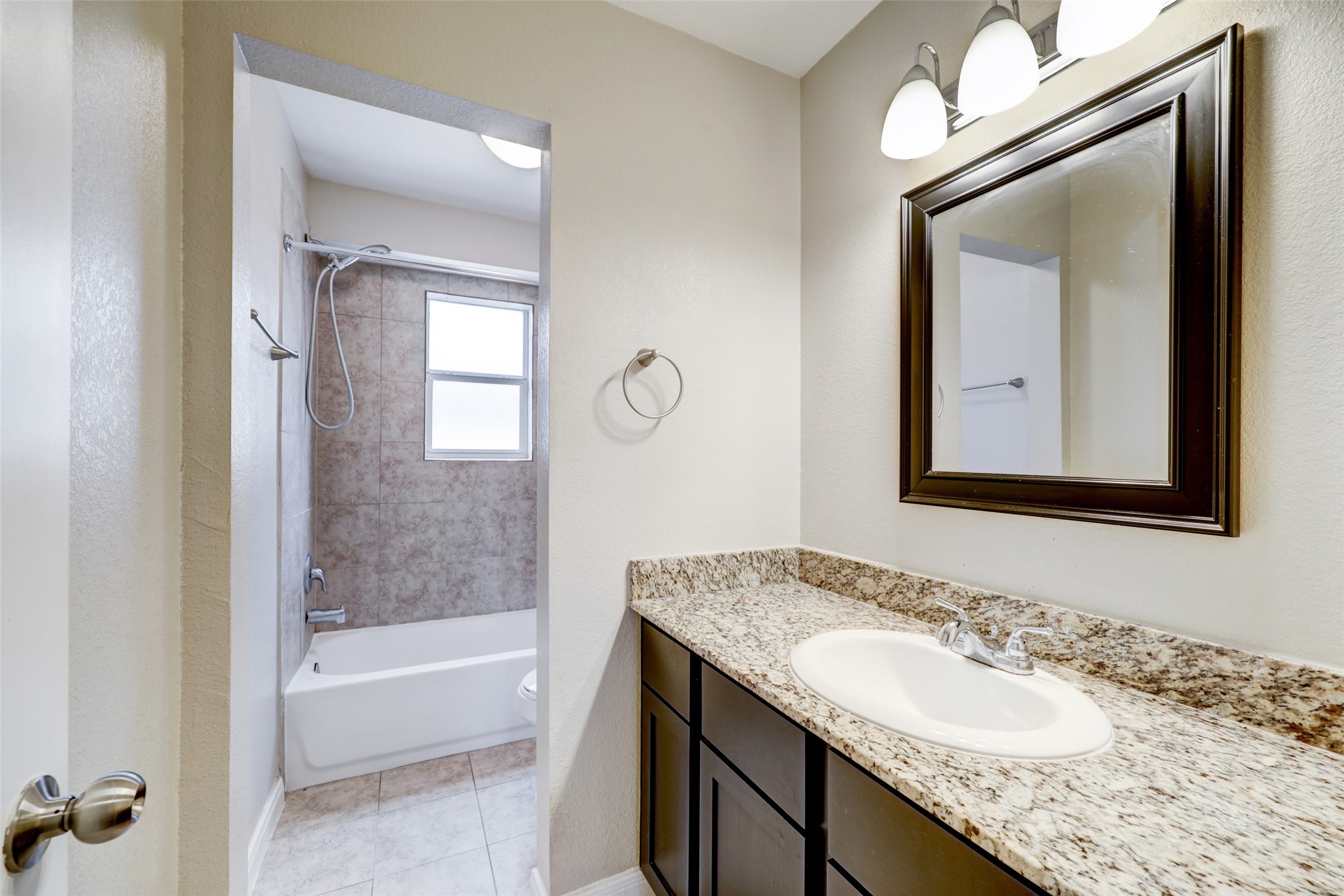 1600 West T C Jester Boulevard, Unit 94 Houston, TX 77008 - Photo 8 of 10 a bathroom with a granite countertop sink and mirror with bathtub