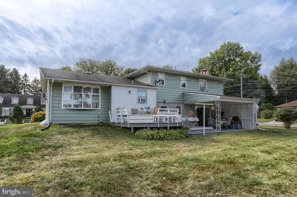 a view of a house with a yard and sitting area