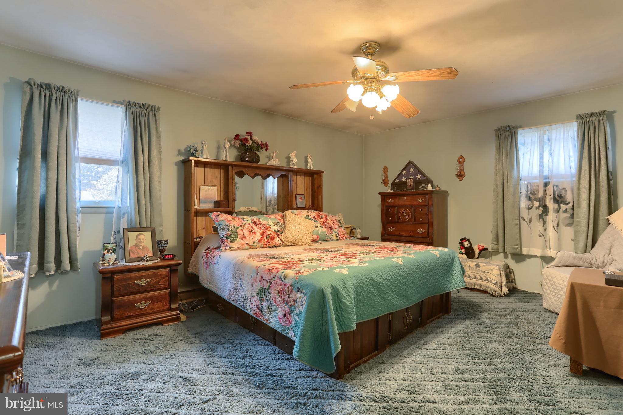 81 Locust Avenue Hershey, PA 17033 - Photo 8 of 18 a bedroom with a large bed and a chandelier