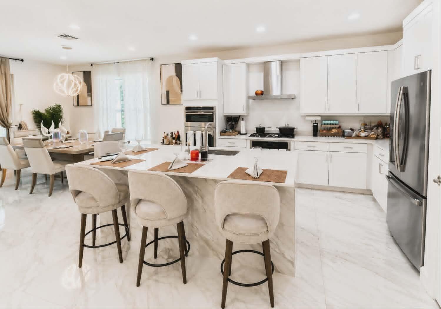 19179 Rolling Acrs Road Loxahatchee, FL 33470 - Photo 13 of 38 a kitchen with stainless steel appliances kitchen island granite countertop a table chairs refrigerator and microwave