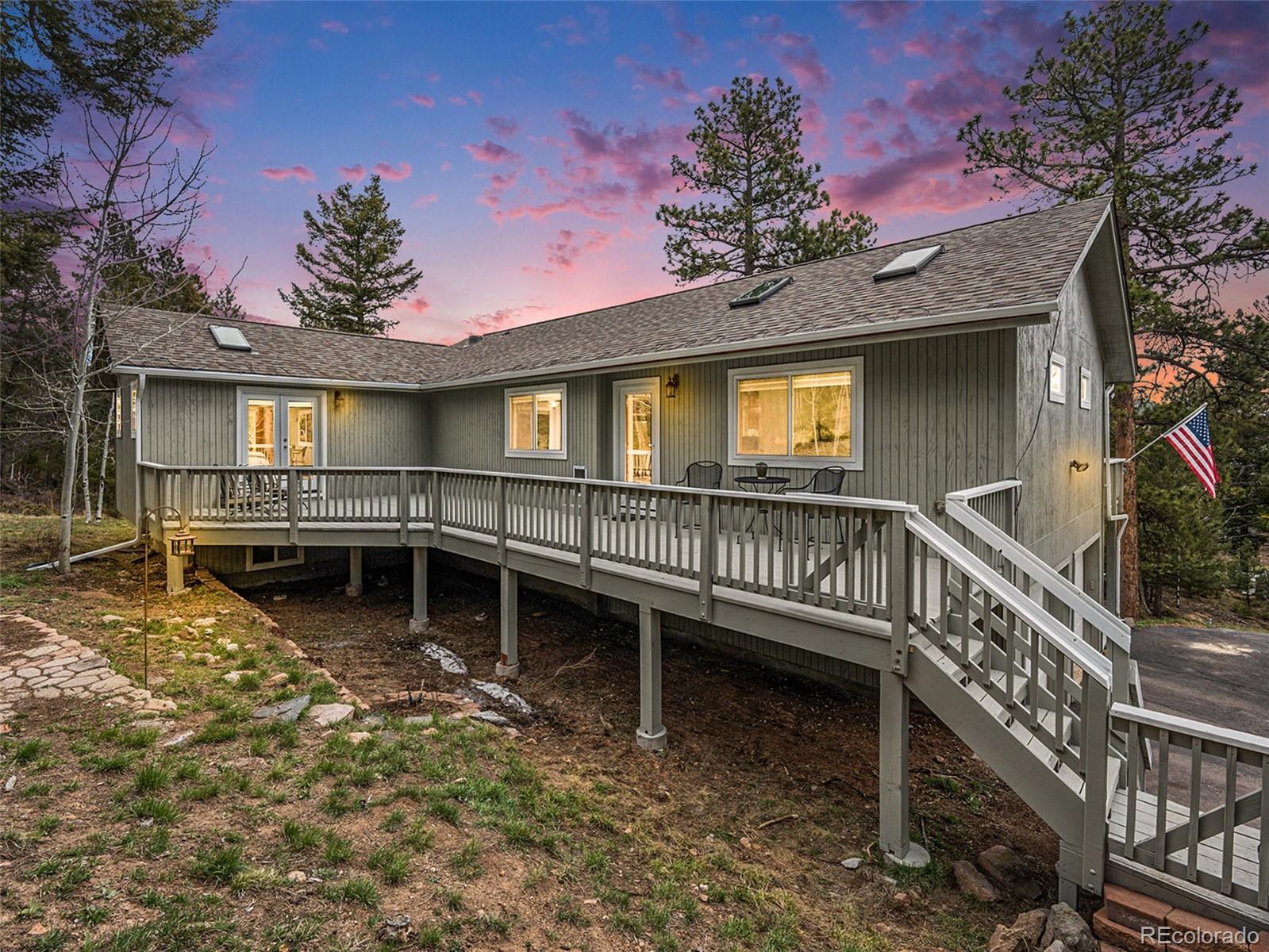 a view of a house with wooden deck and a yard