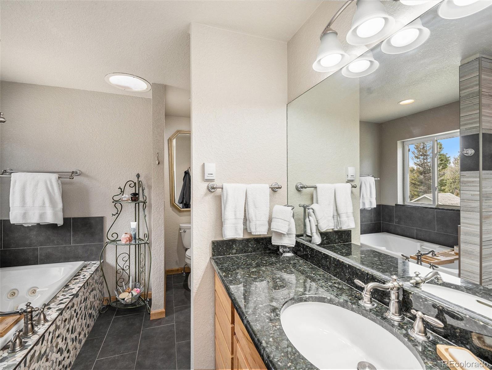 11748 Apache Trail Conifer, CO 80433 - Photo 13 of 34 a bathroom with a granite countertop double vanity sink and a mirror