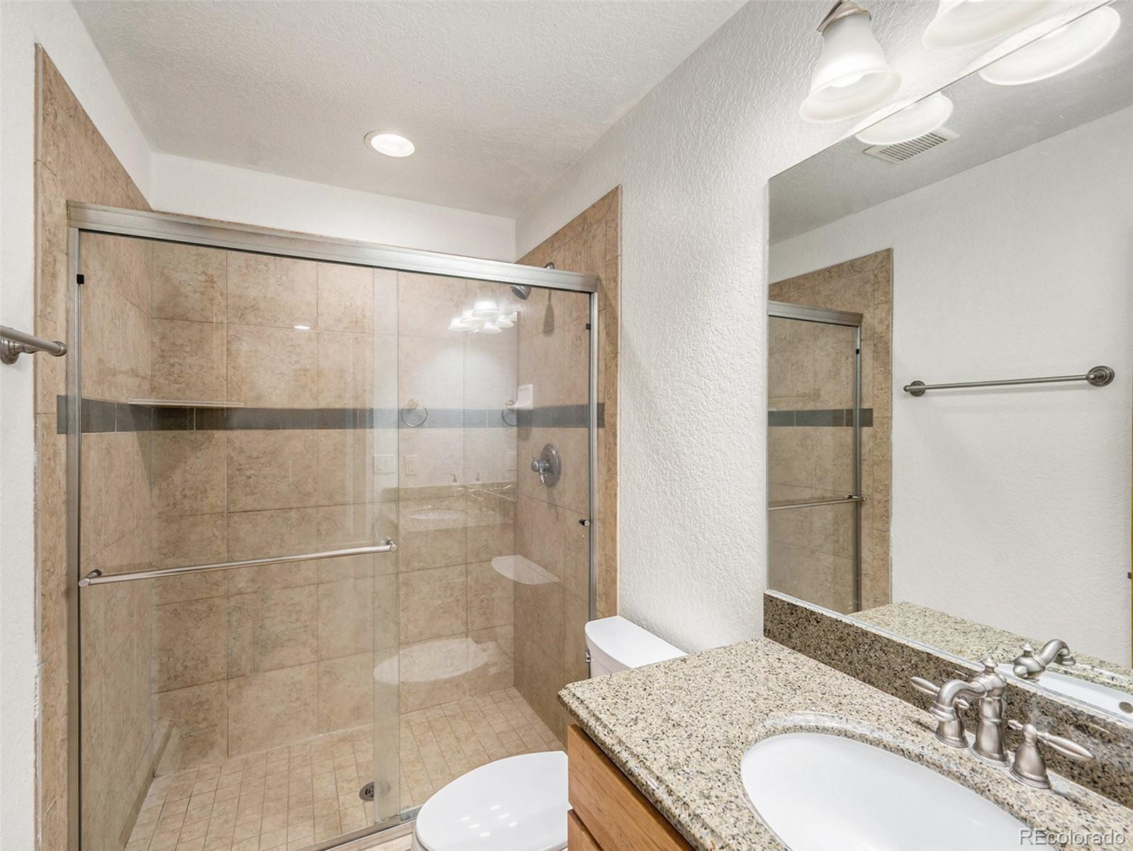 11748 Apache Trail Conifer, CO 80433 - Photo 23 of 34 a bathroom with a granite countertop shower sink and toilet