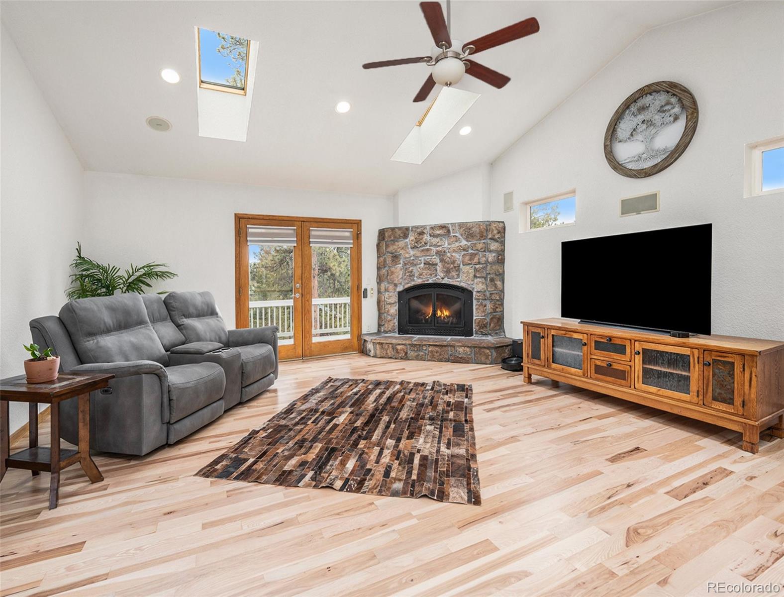 11748 Apache Trail Conifer, CO 80433 - Photo 4 of 34 a living room with furniture a flat screen tv and a fireplace