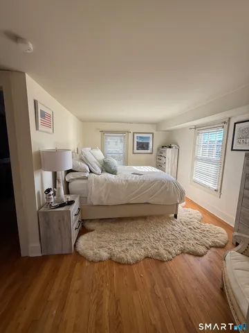 a bedroom with a bed and wooden floor