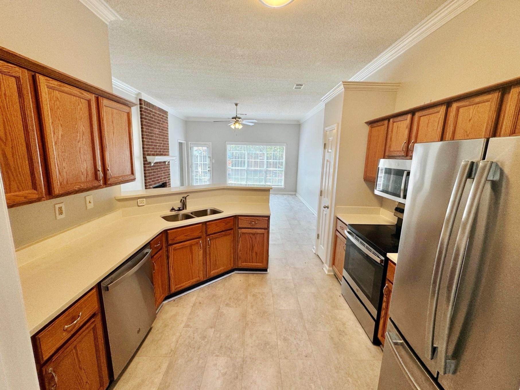 779 North Sanga Road Memphis, TN 38018 - Photo 2 of 12 Kitchen featuring kitchen peninsula, stainless steel appliances, ceiling fan, ornamental molding, and sink