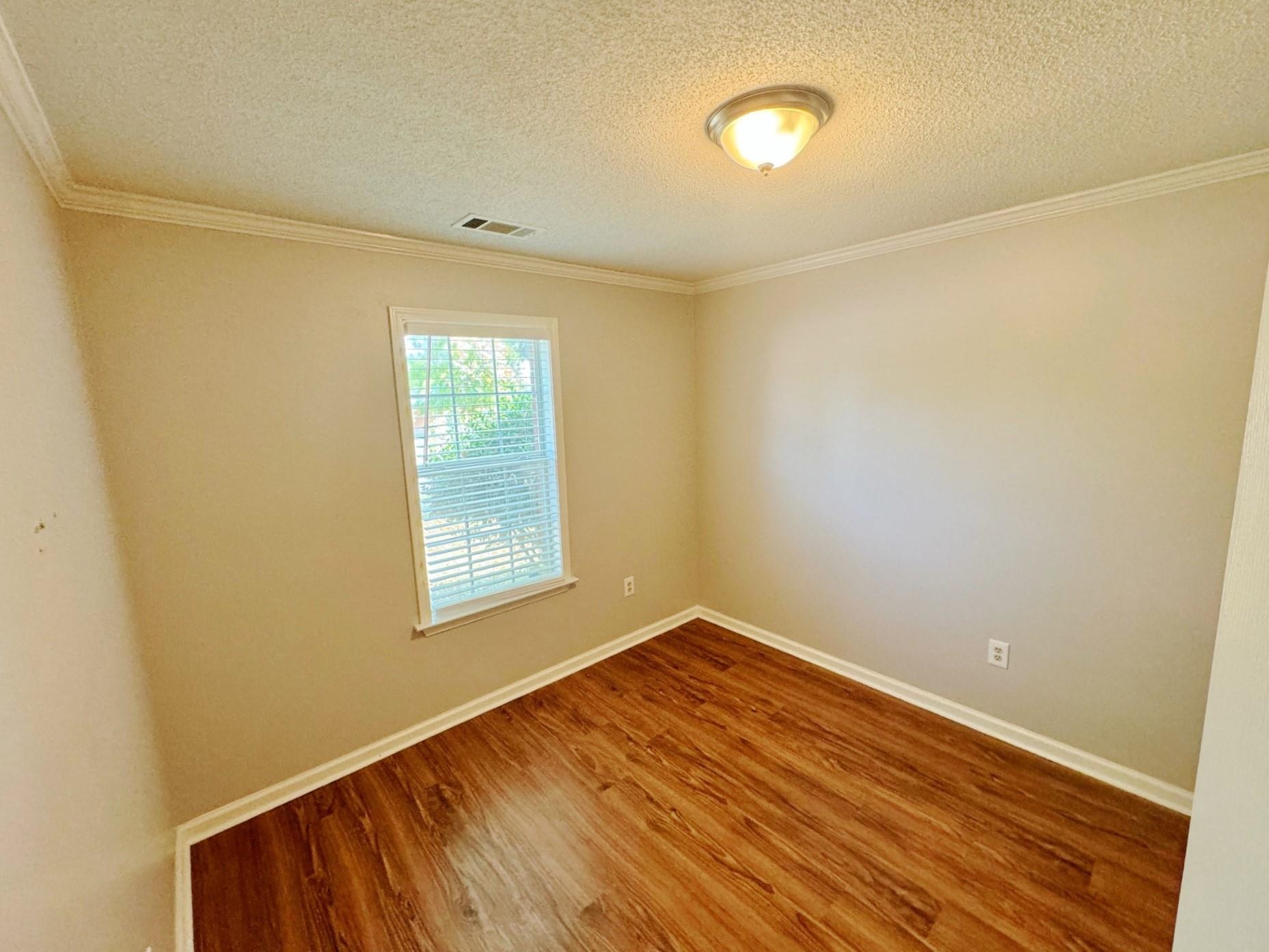 779 North Sanga Road Memphis, TN 38018 - Photo 8 of 12 Empty room with a textured ceiling, crown molding, and hardwood / wood-style floors