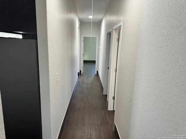 a view of a hallway with wooden floor