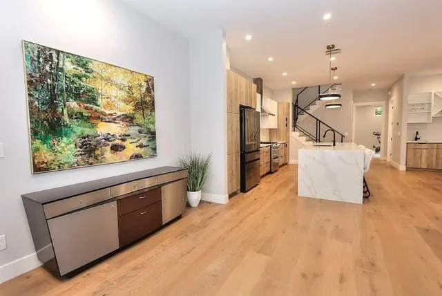 a kitchen with kitchen island a sink stove and wooden floor