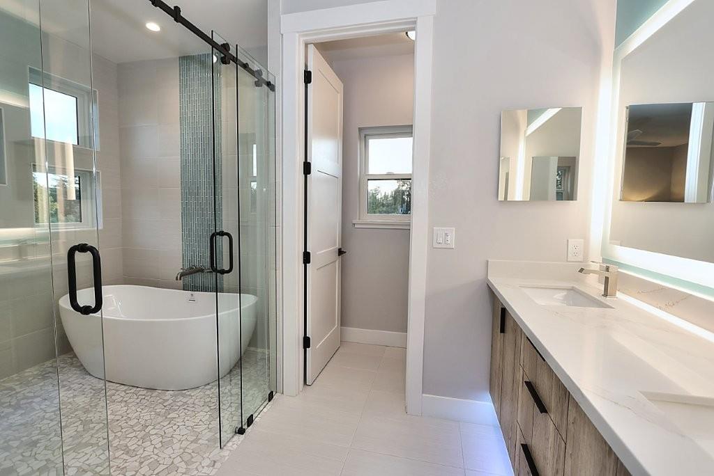 4014 Capitola Hills Court Fair Oaks, CA 95628 - Photo 31 of 59 a bathroom with a tub a double vanity sink and a mirror