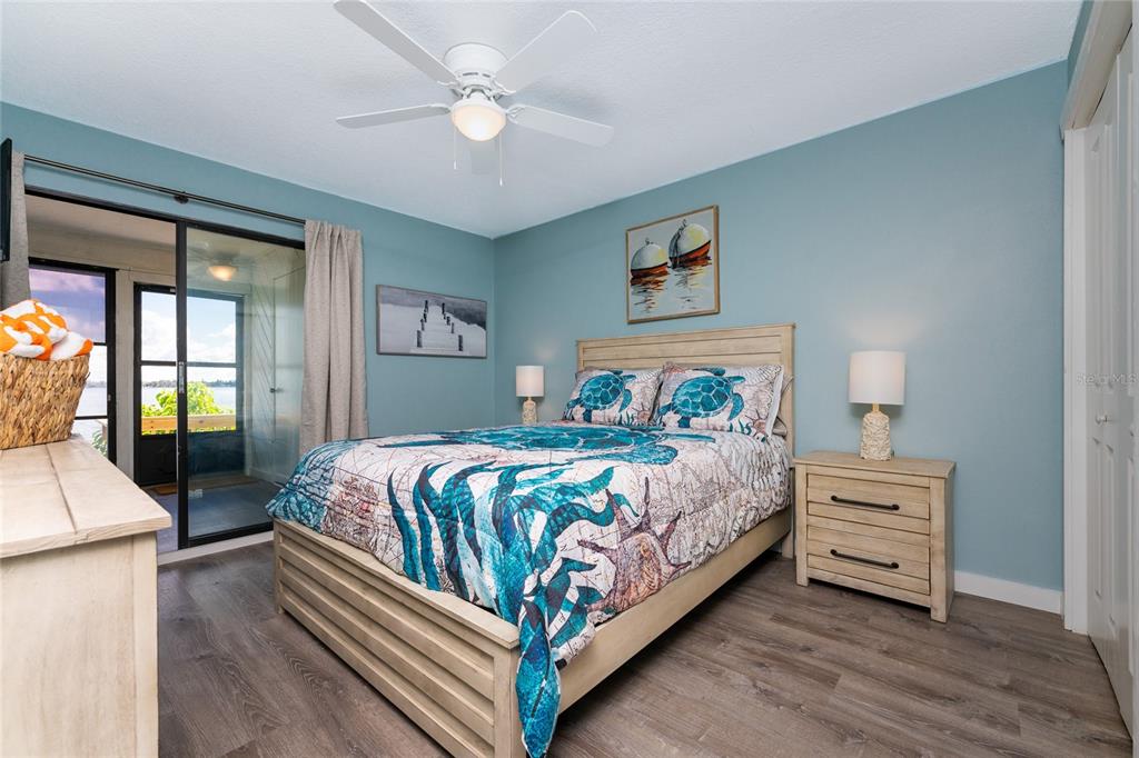 5041 North Beach Road, Unit 1A Englewood, FL 34223 - Photo 11 of 19 a bedroom with a large bed and a chandelier