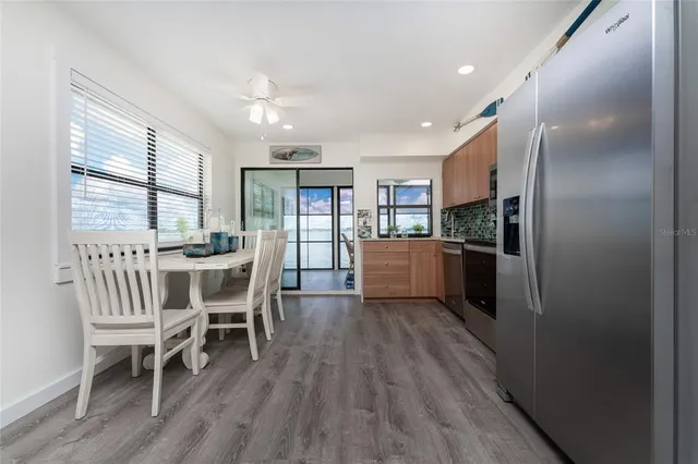 a kitchen with a dining table chairs and refrigerator