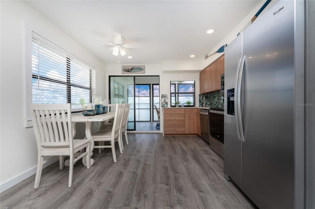 5041 North Beach Road, Unit 1A Englewood, FL 34223 - Photo 6 of 19 a kitchen with a dining table chairs and refrigerator