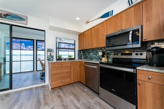 a kitchen with stainless steel appliances wooden cabinets sink and a microwave