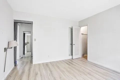 a view of a room with wooden floor and a bathroom