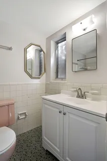 a bathroom with a toilet sink and mirror