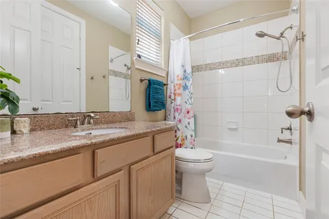 a bathroom with a granite countertop sink a toilet and shower