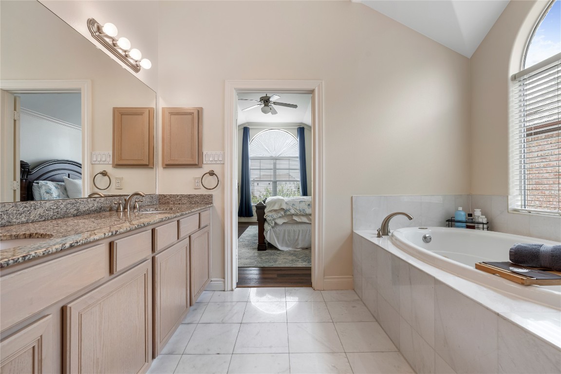 5733 Kansas Street Houston, TX 77007 - Photo 19 of 36 a spacious bathroom with a granite countertop tub sink and mirror