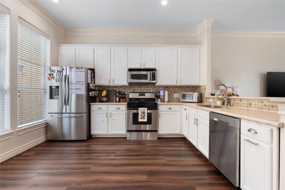 5733 Kansas Street Houston, TX 77007 - Photo 30 of 36 a kitchen with a refrigerator stove and wooden cabinets