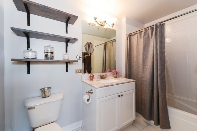 910 West Madison Street, Unit 501 Chicago, IL 60607 - Photo 8 of 11 a bathroom with a sink a toilet and mirror