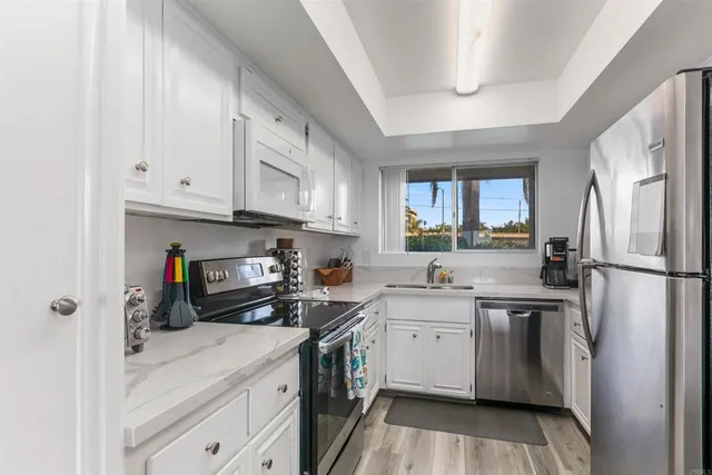 a kitchen with stainless steel appliances a stove refrigerator sink and cabinets