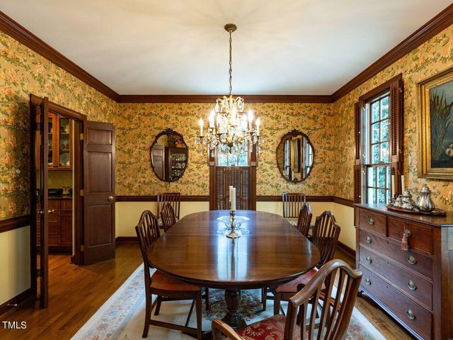 a dining room with furniture a chandelier and wooden floor