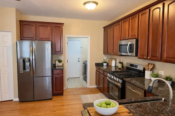 a kitchen with stainless steel appliances granite countertop a refrigerator stove and sink