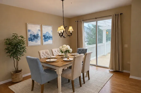 a dining room with furniture a large window and a chandelier