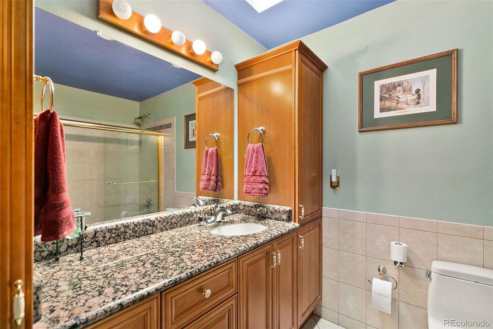 13 Maple Drive Frederick, CO 80530 - Photo 22 of 32 a bathroom with a granite countertop sink and a mirror
