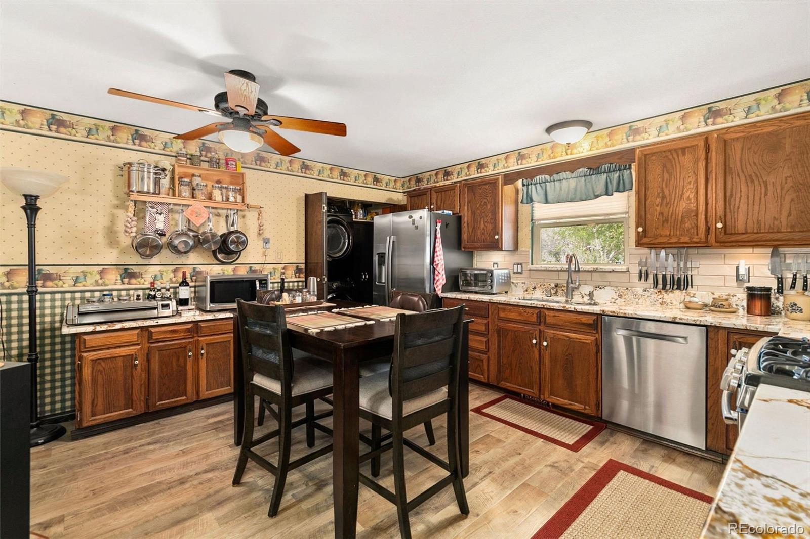 13 Maple Drive Frederick, CO 80530 - Photo 4 of 32 a kitchen with stainless steel appliances granite countertop wooden cabinets a table and chairs
