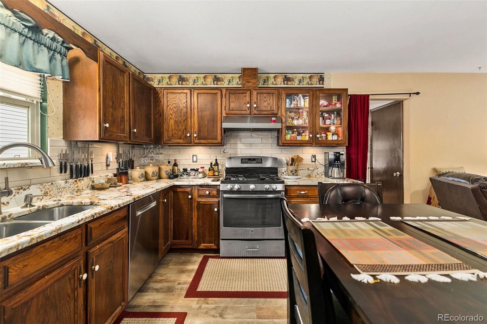 13 Maple Drive Frederick, CO 80530 - Photo 5 of 32 a kitchen with stainless steel appliances granite countertop a stove a sink and a refrigerator