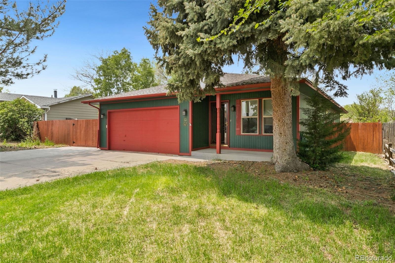 13 Maple Drive Frederick, CO 80530 - Photo 9 of 32 a front view of a house with a garden and tree