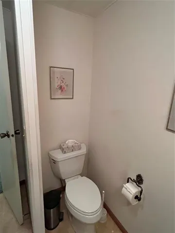 a bed sitting in a spacious bedroom next to a window and a flat screen tv