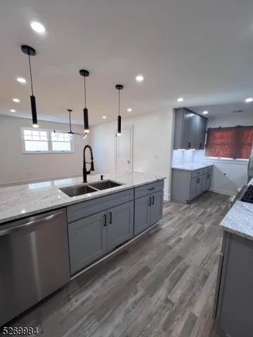 a large kitchen with a lot of counter space and wooden floor