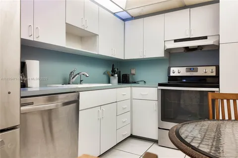 a kitchen with white cabinets and appliances