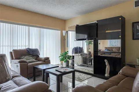 a living room with furniture a large window and a fireplace