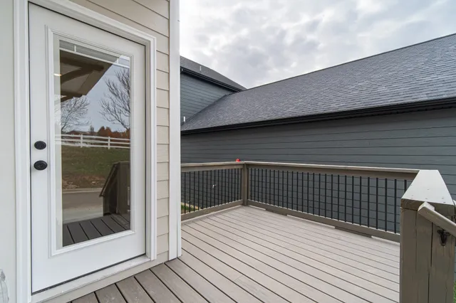 an empty room with wooden floor chandelier fan and windows
